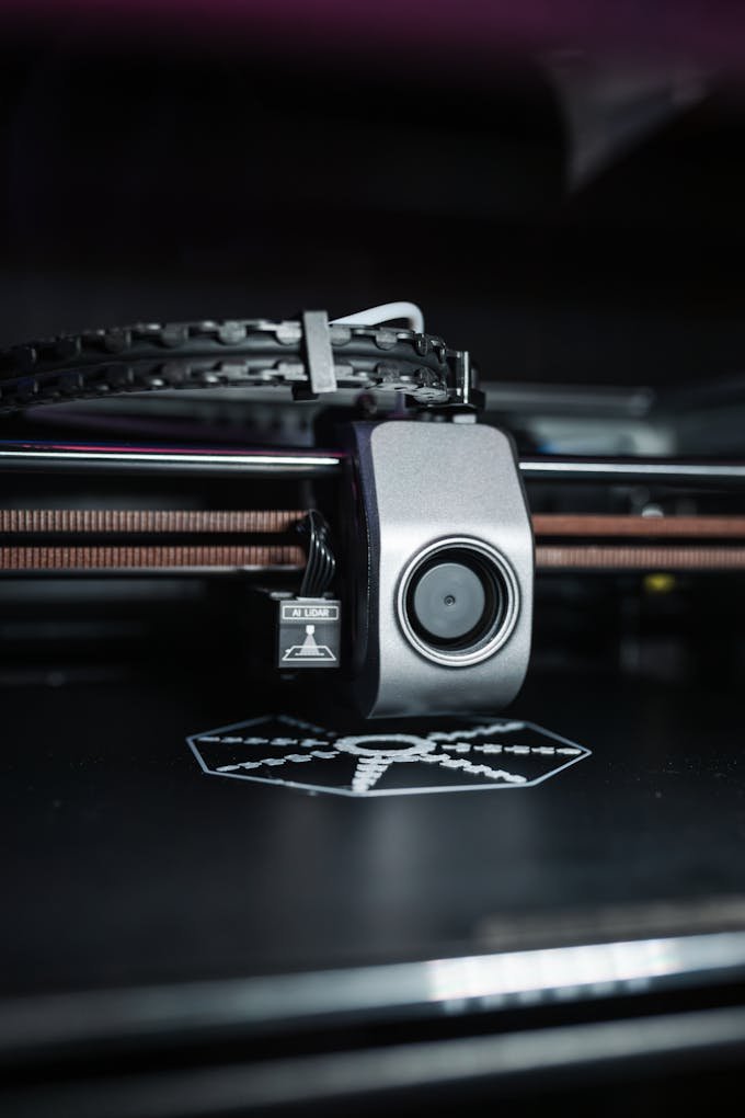 Detailed close-up view of a modern 3D printer in operation, focusing on the printhead.